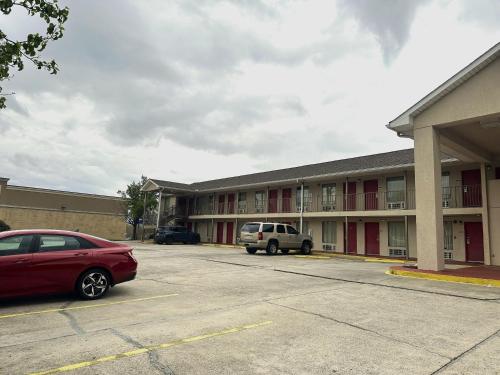 a red car parked in front of a building at OYO Hotel East Macon I-75 in Macon