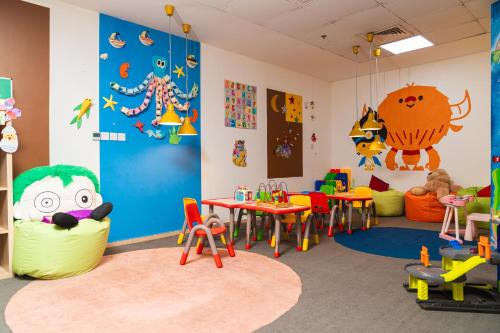 a kindergarten classroom with tables and chairs and toys at Al Raha Beach Resort & Spa in Abu Dhabi