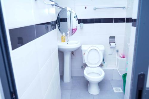 a small bathroom with a toilet and a sink at S&J Luxury Homes Mombasa in Mombasa
