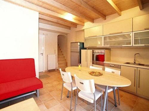a kitchen with a table and chairs and a red couch at Holiday Residence Rodanthi, Darmarochori in Darmarochori