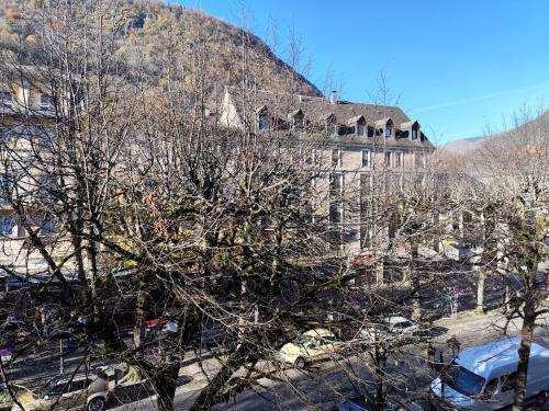 an old building with trees in front of it at appartement T1 hyper centre 350 m des thermes 200 m des télécabines deuxième étage avec ascenseur in Luchon