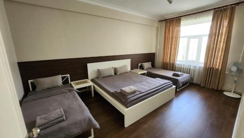 a bedroom with two beds and a window at Zaya Stays Heart of Ulaanbaatar Main Square in Ulaanbaatar