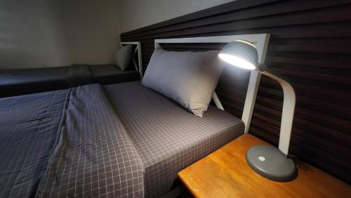 a bedroom with a bed with a lamp on a wooden table at Zaya Stays Heart of Ulaanbaatar Main Square in Ulaanbaatar