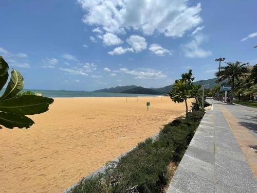 a sandy beach with palm trees and the ocean at Khách sạn Đông Tây Quy Nhơn in Quy Nhon