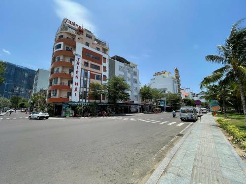 a city street with a building and cars on the road at Khách sạn Đông Tây Quy Nhơn in Quy Nhon