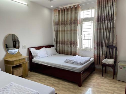a small bedroom with a bed and a window at Khách sạn Đông Tây Quy Nhơn in Quy Nhon