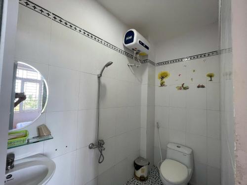 a white bathroom with a toilet and a sink at Khách sạn Đông Tây Quy Nhơn in Quy Nhon