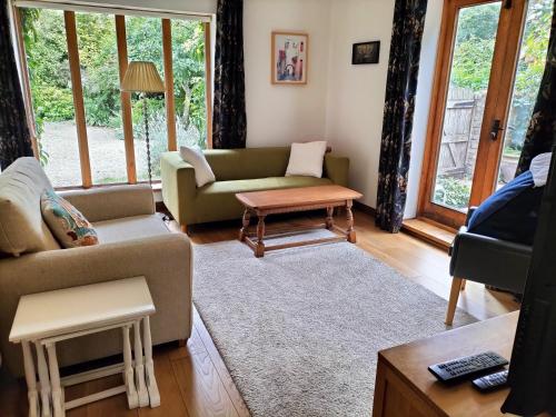 a living room with a couch and a table at Fig Tree Cottage 