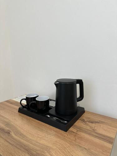 two black coffee cups sitting on a black tray at Турист in Astana