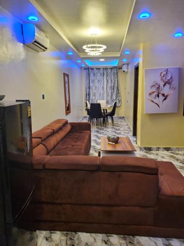 a living room with a brown couch and a table at Romeo Suites & Apartment in Ipaja