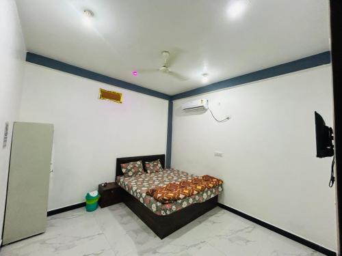 a bedroom with a bed in the corner of a room at Hotel Sanskar in Dodi