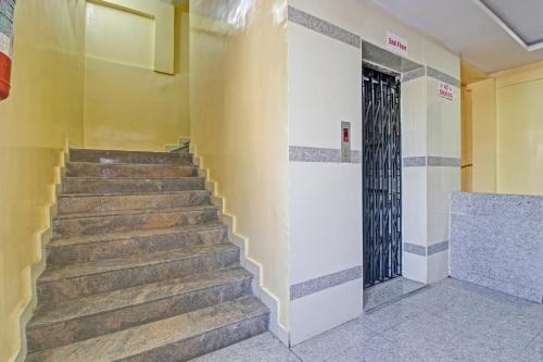 a staircase in a building with a yellow wall and a door at Hotel O Sri Sai Regency in Hyderabad