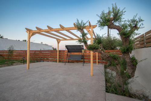a wooden pergola with a grill in a garden at Aurum Luxury Villa Voz by elite" in Laganas