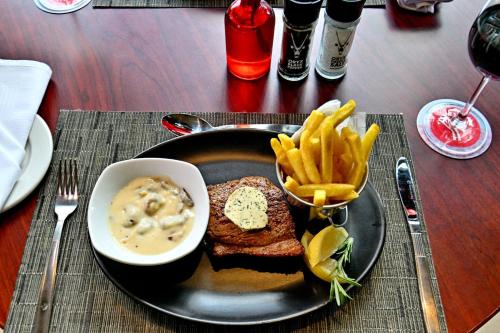a plate of food with a sandwich and french fries at City Lodge Hotel Bryanston in Johannesburg