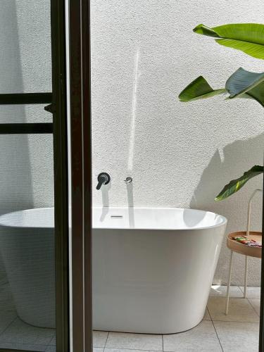 baño con bañera blanca y planta en Hsia Mu Le, en Zhongpu