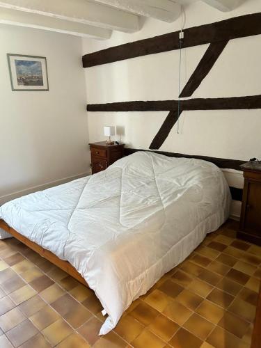 アルジャン・シュル・ソルドルにあるLa maison d'Elianeの白いベッドと木製の梁が備わるベッドルーム1室