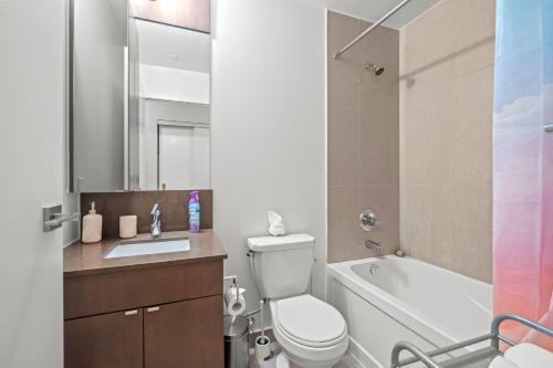 a bathroom with a toilet and a sink and a tub at luminous 2-Bedroom Apartment with Balcony in Toronto