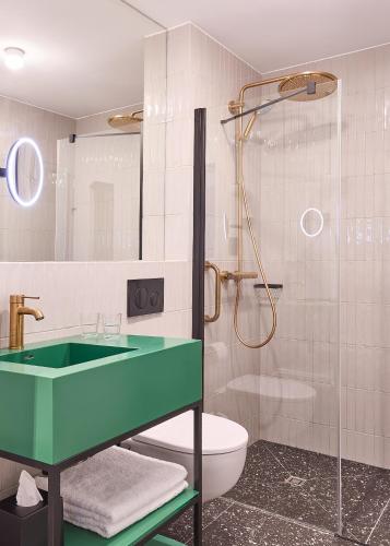 a bathroom with a green sink and a toilet at Wroclaw Hotel in Wrocław