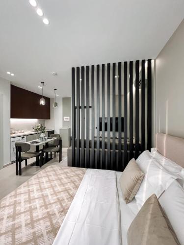 a bedroom with a white bed and a dining room at Tirana Bliss Appartment 103 in Tirana
