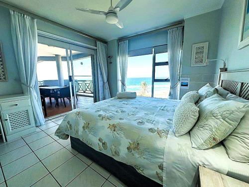 a bedroom with a bed with a view of the ocean at Tahiti Dreaming in Umdloti