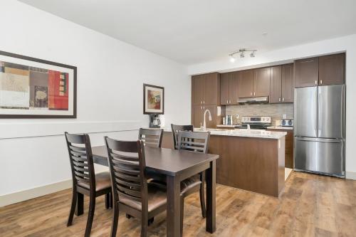 Una cocina con mesa y sillas y un refrigerador. en 2BR Unit Harrison Mountain View, en Harrison Hot Springs