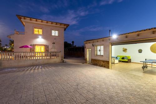 a house with a large patio with a table on it at Fields & Beachside Villa by Fidalsa in Jacarilla