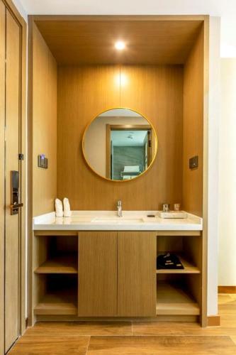 a bathroom with a sink and a mirror at 万信至格酒店乌鲁木齐机场德港万达店 in Ürümqi