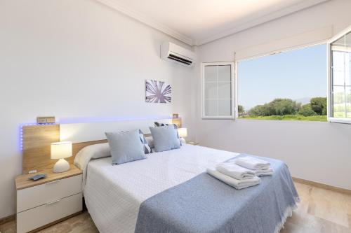 a white bedroom with a bed and a window at Fields & Beachside Villa by Fidalsa in Jacarilla