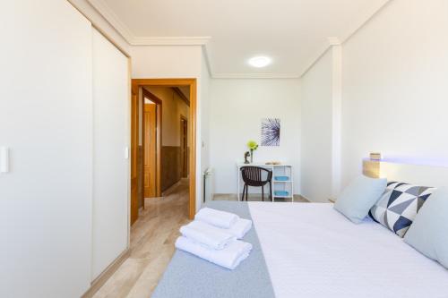 a bedroom with a white bed with towels on it at Fields & Beachside Villa by Fidalsa in Jacarilla