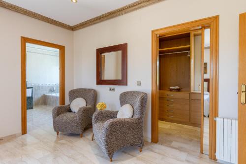 a living room with two chairs and a mirror at Fields & Beachside Villa by Fidalsa in Jacarilla
