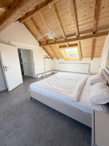 a large bed in a room with a wooden ceiling at Neues, stilvolles Loft inmitten der Weinberge 