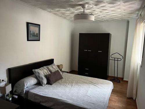 a bedroom with a bed and a black door at Piso a 3 minutos de la playa!! 6 personas in Cullera