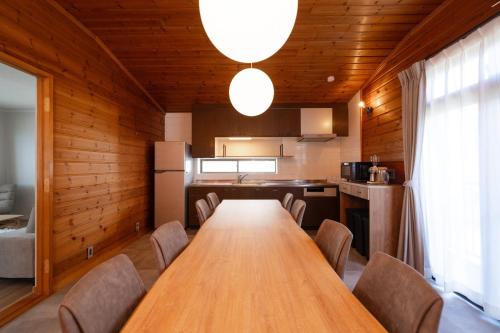 a dining room with a long wooden table and chairs at mion - Vacation STAY 52998v in Hota