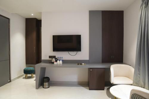 a room with a desk with a tv and a chair at Hotel Godwin in Deoghar