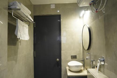 a bathroom with a black door and a toilet and a mirror at Hotel Godwin in Deoghar