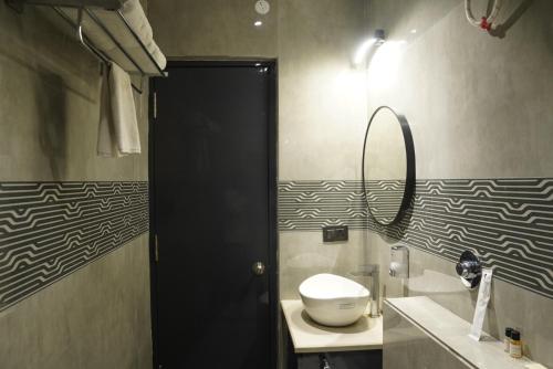 a bathroom with a toilet and a sink and a mirror at Hotel Godwin in Deoghar