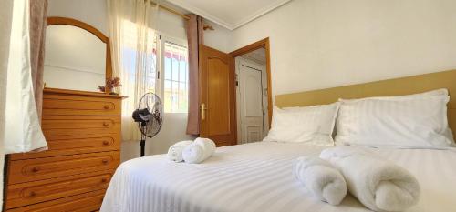 a bedroom with a white bed with towels on it at La Mata Rooftop Terrace with 100m to Beach in La Mata