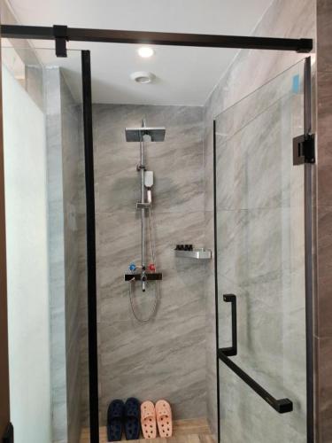 a shower with a glass door in a bathroom at 万信至格酒店乌鲁木齐机场德港万达店 in Ürümqi