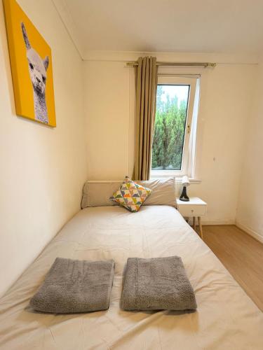 a bedroom with a bed with two pillows on it at Lovely Maindoor flat at Murrayfield with Gardens in Edinburgh
