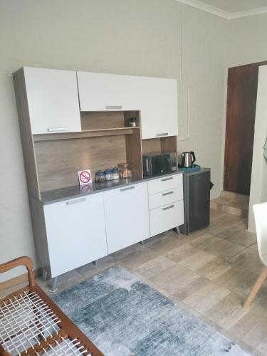 a kitchen with white cabinets in a room at Breakaway Base in Strand
