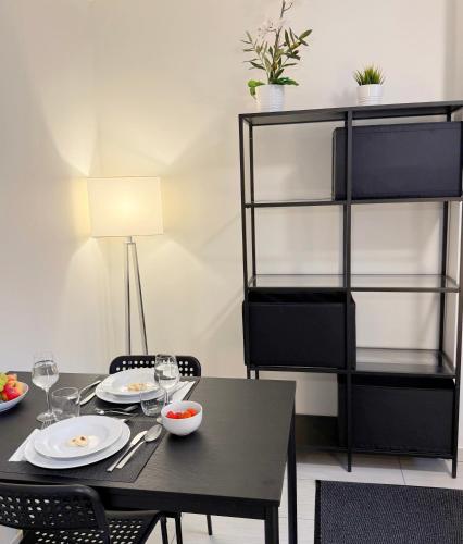 une salle à manger avec une table et des chaises noires dans l'établissement BASELiving Studio 2 - Bahnhof SBB, à Bâle