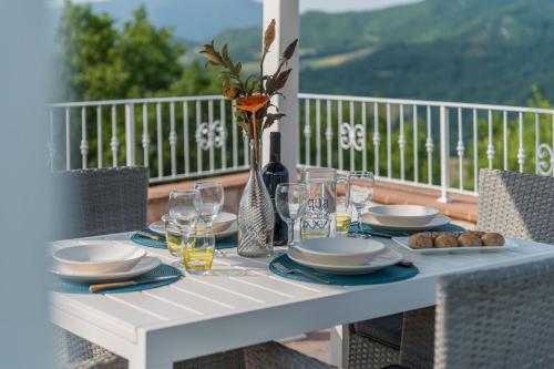 a white table with plates and glasses on a balcony at Villa Azzurra in Pesaro