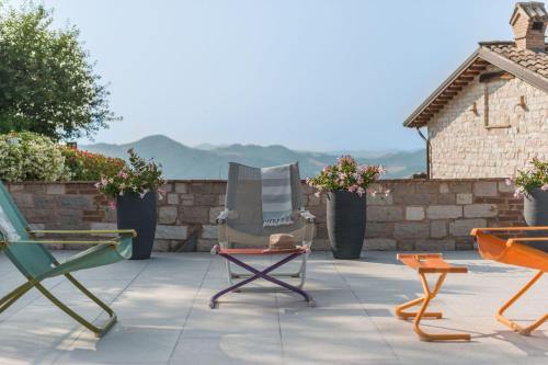 two chairs sitting on a patio with mountains in the background at Villa Azzurra in Pesaro