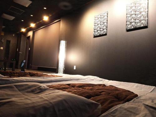 名古屋市にあるKorin - Vacation STAY 60460vの照明付きの部屋に数台のベッドが備わる部屋