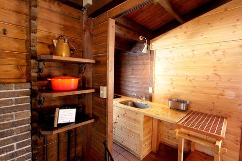 eine Küche mit einem Waschbecken in einer Holzhütte in der Unterkunft Kitakaruizawa Sweet Grass - Vacation STAY 82370v in Kita-karuizawa