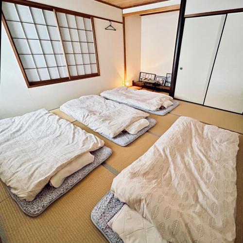 three beds sitting in a room with windows at Makeit 1to3 - Vacation STAY 17356 in Chichibu