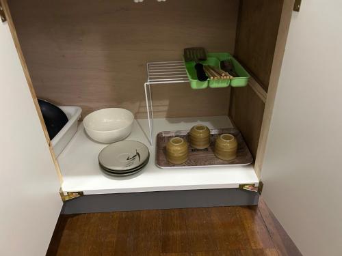 un placard avec des assiettes et des bols dessus dans l'établissement Chambord Kyomachi - Vacation STAY 64829v, à Kumamoto