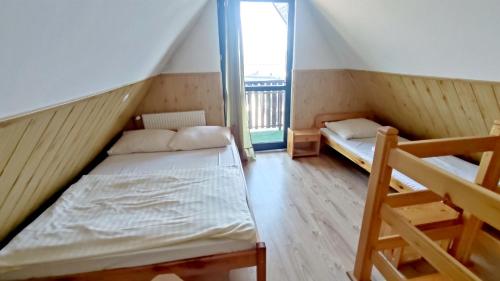 a small room with two beds and a balcony at Pokoje Gościnne Barka - 300m do RESTAURACJI - 900m do JEZIORA i VELO CZORSZTYN in Kluszkowce