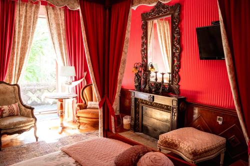a red room with a fireplace and a mirror at Château de la Grange Fort in Issoire