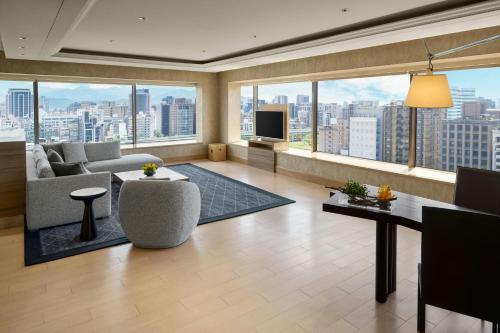 a large living room with a view of a city at Sheraton Grand Taipei Hotel in Taipei